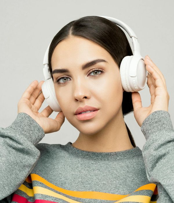 Woman with a serene face and closed eyes, focusing inward.